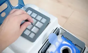 Dłoń wymienia filtr w odkurzaczu. To ważny element, czy to filtr EPA, czy HEPA, zapewnia czyste powietrze.