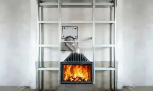 Palący się kominek z metalową obudową i rurą odprowadzającą spaliny. Konstrukcja z profili stalowych wokół, sugerująca budowę obudowy. Jaka rura do kominka będzie najlepsza?
