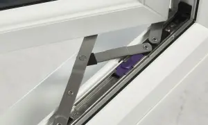 Mechanizm okna uchylno-rozwiernego, pokazujący jak zdjąć okno plastikowe z zawiasów. Fioletowy element blokujący.