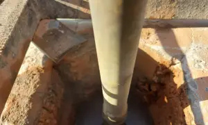 Wiertło zagłębia się w ceramiczny komin, rozpoczynając jego naprawę.