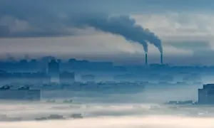 Mglisty poranek nad miastem, z kominów fabrycznych wydobywa się dym. O3 co to za zanieczyszczenie?