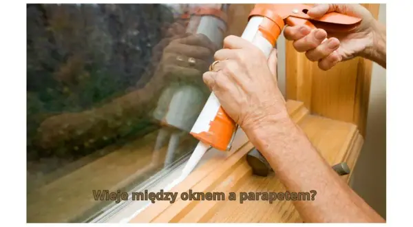 Uszczelnianie okna, gdy wieje między oknem a parapetem. Dłoń z pistoletem do silikonu aplikuje białą masę.