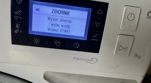 Na wyświetlaczu pralki komunikat: "ZBIORNIK. Wysuń zbiornik i wylej wodę. Wciśnij START". Dużo wody w pojemniku na skropliny.