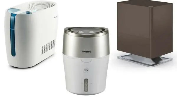 Trzy nawilżacze powietrza. Jeden biały z niebieskim elementem, drugi Philips biało-srebrny, trzeci brązowy. Uważaj, by nie postawić ich na mokrej podłodze.