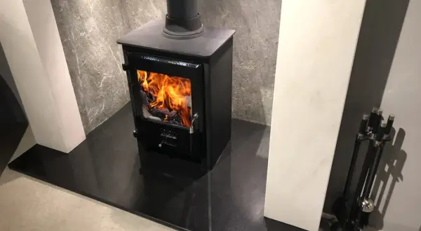 Nowoczesny kominek z palącym się ogniem. Czy warto zainwestować w taki radiator do kominka?