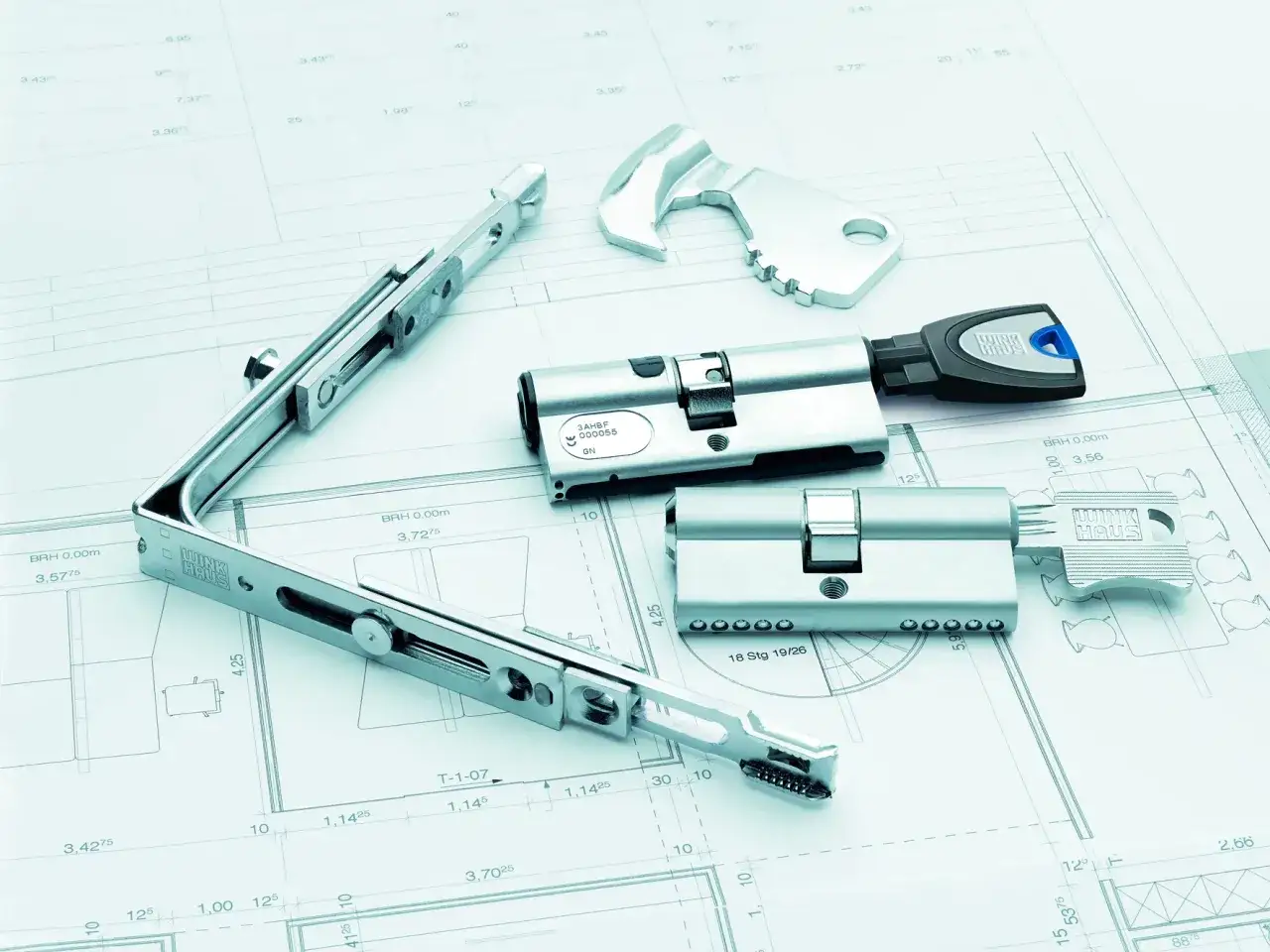 Elementy systemu zabezpieczeń Winkhaus zamek, klucze i mechanizm na tle planów technicznych.