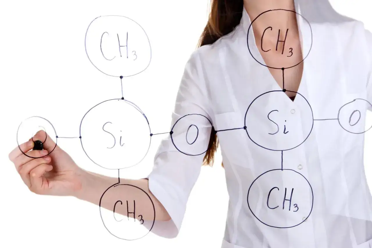 Badaczka rysuje wz&oacute;r chemiczny, przedstawiający niemetanowe lotne związki organiczne, takie jak siloksany.