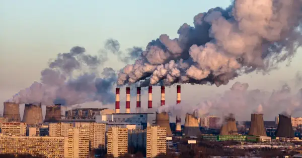 Dymiące kominy elektrowni nad miastem, świadczące o złej jakości powietrza.