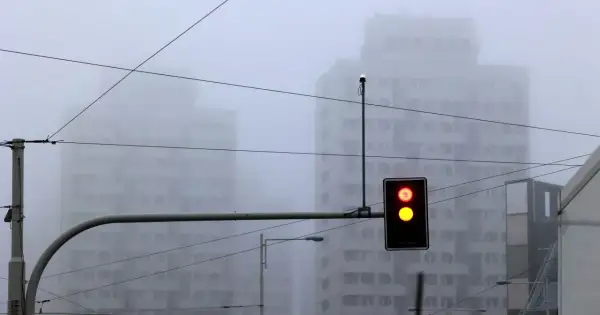Mgła tak gęsta, że czuć ją w powietrzu. Sygnalizacja świetlna pokazuje czerwone i żółte światło, budynki znikają we mgle.