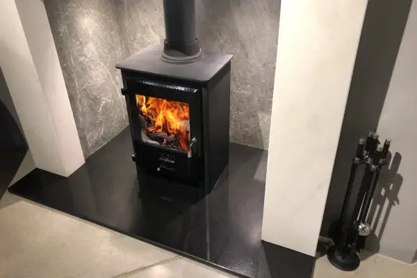 Nowoczesny kominek z palącym się ogniem. Czy warto zainwestować w taki radiator do kominka?